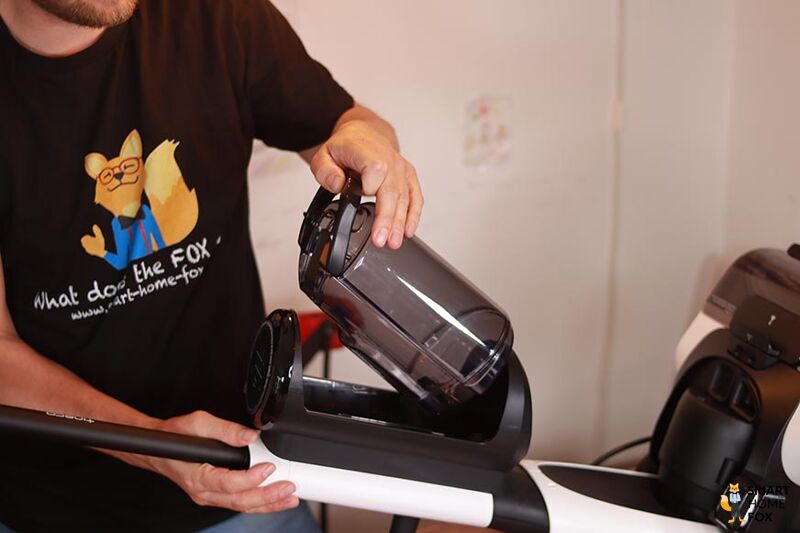 The tank is being removed from a carpet cleaner for cleaning.